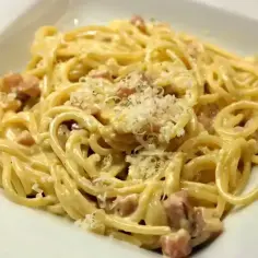 Pyszne spaghetti carbonara z kawałkami guanciale i parmezanem. Idealna odpowiedź na pytanie: jaka śmietana do carbonary?