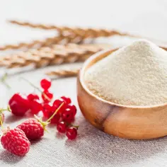 Miseczka z semoliną, obok świeże maliny, truskawki i porzeczki. To właśnie semolina co to za produkt?