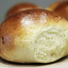 Złocista bułka brioche, idealna na śniadanie, z puszystym wnętrzem i lekko chrupiącą skórką.