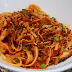 Pyszny makaron udon w sosie pomidorowym z czarnym sezamem i szczypiorkiem. Idealny makaron udon przepis na szybki obiad.