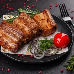 Soczyste, miękkie żeberka z grilla, podane z pomidorkiem, cebulą i ziołami. Idealne na letni wieczór.