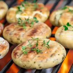 Aksamitne halloumi na grilla, z rumianymi paskami i gałązkami tymianku, skwierczy nad ogniem.