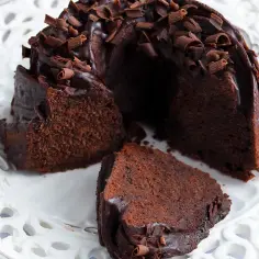 Pyszna babka z mascarpone i kakao, oblana czekoladą i posypana wiórkami. Idealna na deser.