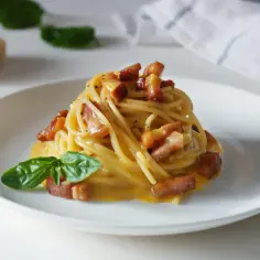 Pyszna carbonara z boczkiem i bazylią. Jaki ser do carbonary? Najlepszy jest parmezan, który widać na zdjęciu obok.