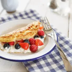 Puszysty omlet z twarożkiem i świeżymi owocami leśnymi. Idealny przepis na omlet na śniadanie.