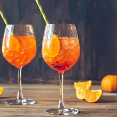 Dwa Aperol Spritz z plasterkiem pomarańczy i słomką. Idealny przepis na lato.