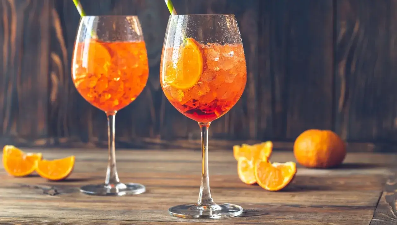Dwa orzeźwiające Aperole z pomarańczą i lodem, idealne proporcje na letnie popołudnie.