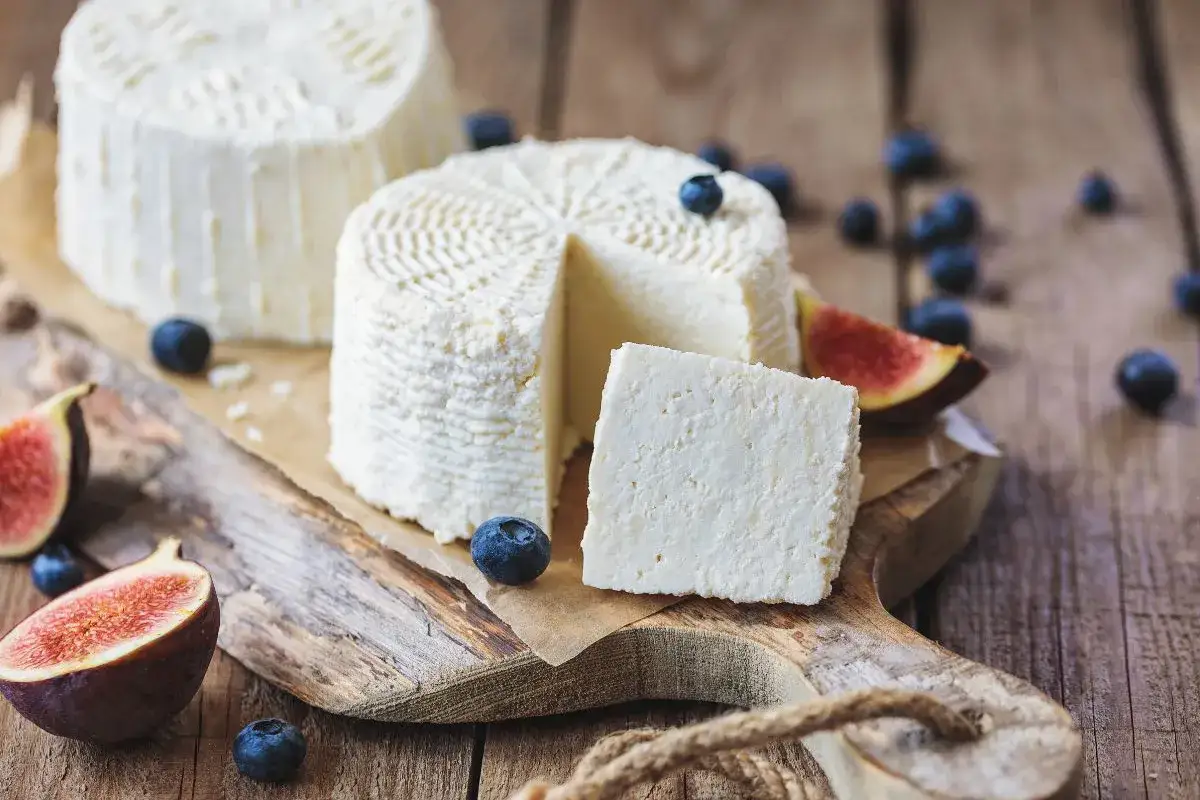 Świeży serek ricotta na desce z figami i borówkami. Idealny na lekki posiłek.