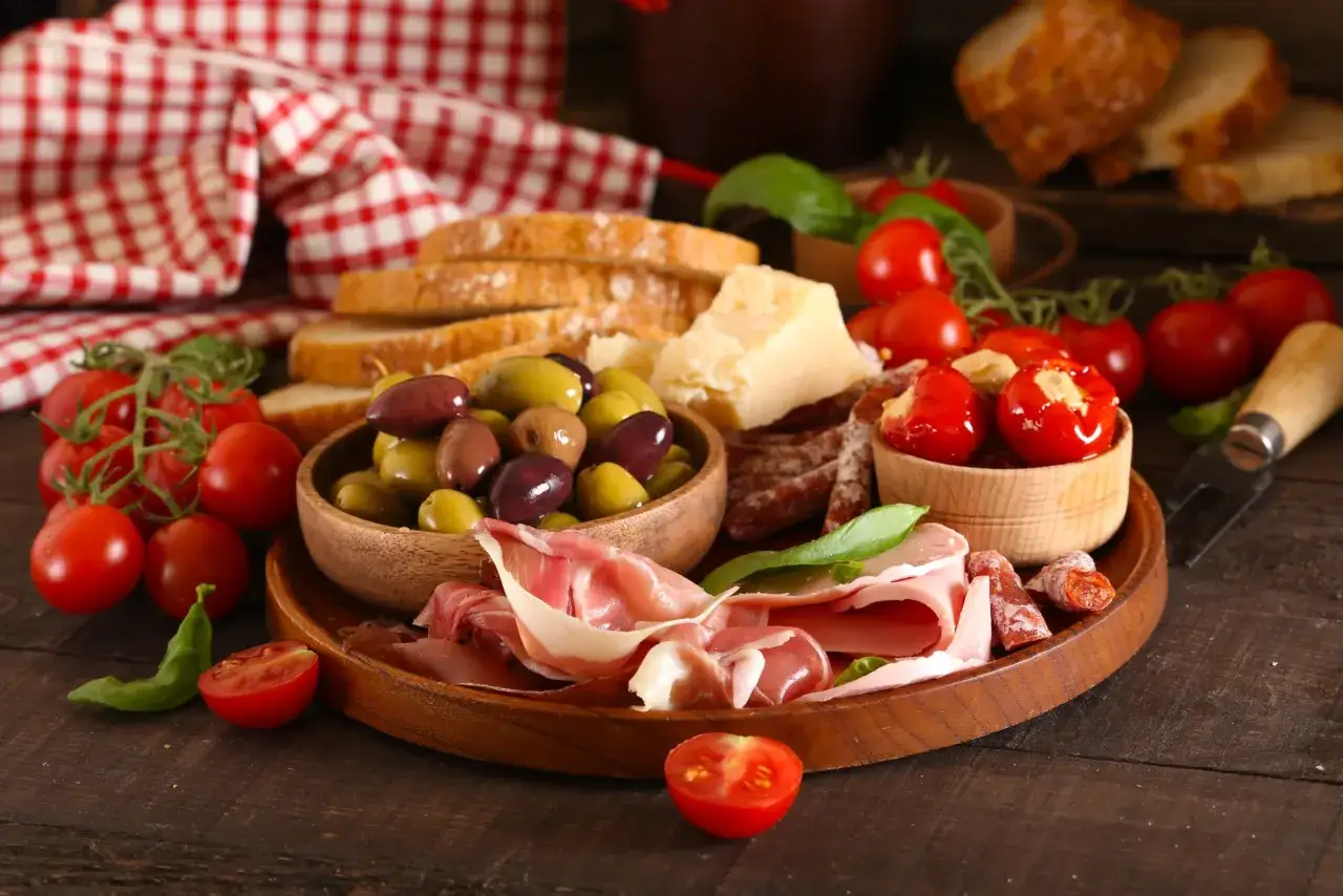 Deska serów i wędlin z pomidorkami, oliwkami, chlebem i plasterkami salami napoli.