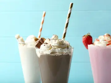 Jak zrobić shake? Trzy pyszne desery: waniliowy z rurkami waflowymi, czekoladowy z kawałkami czekolady i truskawkowy z owocem.